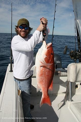 GREAT FIGHT: I hold up a 25-pound red snapper before releasing the fish into the depths. Photo by Conor Harrison, LSON. asnapper4